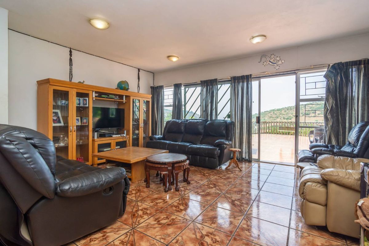 Spacious living room featuring tiled flooring, built-in display cabinetry, and large sliding glass doors providing access to an outdoor patio area.