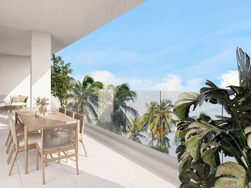 A spacious, modern covered balcony featuring sleek glass balustrades and light-toned floor tiles, offering an open-air space perfect for outdoor dining and relaxation.