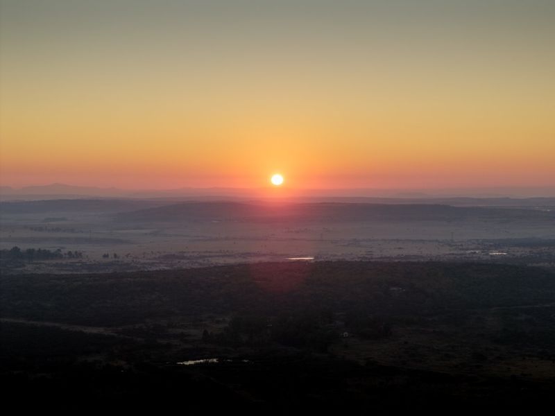 A scenic sunrise view overlooking the expansive landscape and rolling hills surrounding the property.