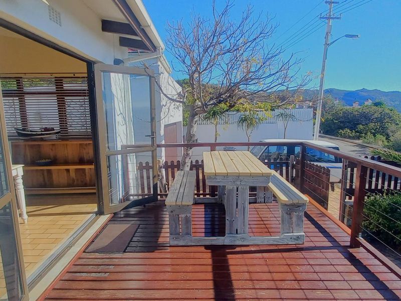 An elevated timber deck patio featuring bi-fold doors providing seamless indoor-outdoor flow and scenic views.