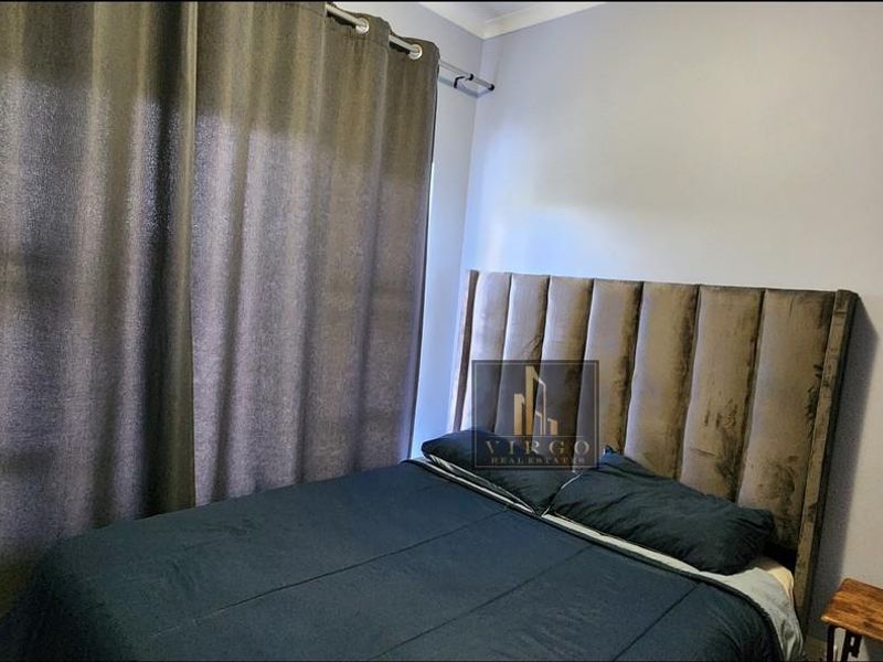 A bedroom featuring neutral wall finishes and a curtain rail, providing a functional space for rest.