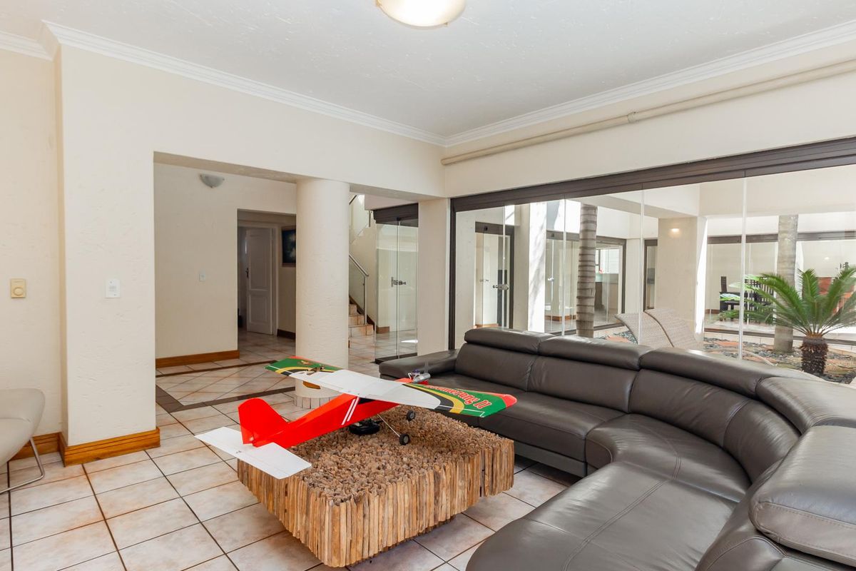 Spacious living area featuring large glass sliding doors that open to an internal courtyard, providing ample natural light and a seamless indoor-outdoor flow.