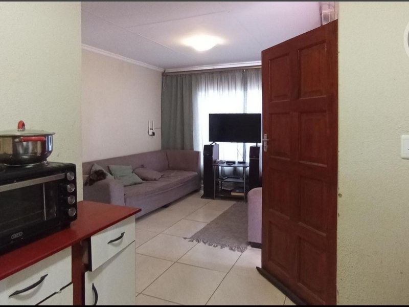 Open plan living area featuring tiled flooring and direct access to the kitchen space.