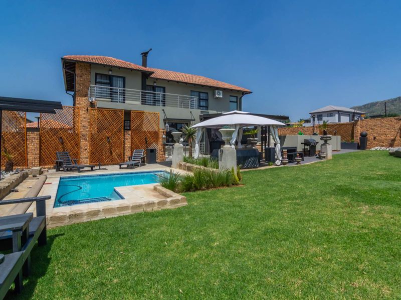 Spacious rear garden featuring a swimming pool, paved patio area, and brick boundary walls, offering an ideal space for outdoor entertainment.