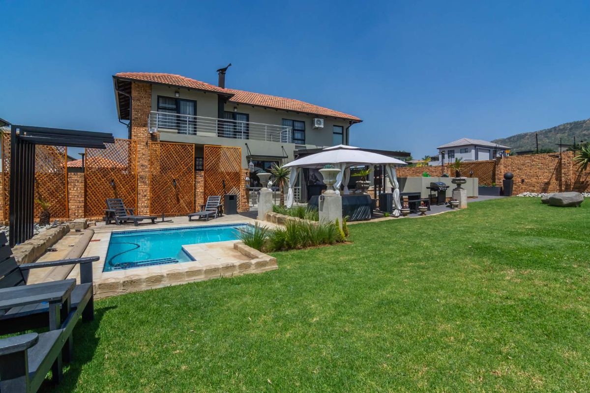 Spacious rear garden featuring a swimming pool, paved patio area, and brick boundary walls, offering an ideal space for outdoor entertainment.