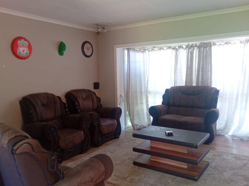 A living room area featuring laminate flooring and a large sliding glass door that provides natural light.