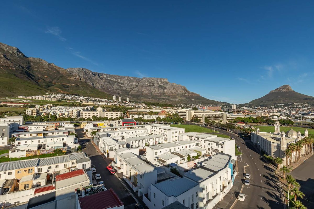 An elevated aerial view overlooking a residential apartment complex with Table Mountain in the background.