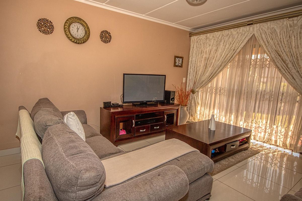 A comfortable living room featuring tiled flooring and sliding glass doors that provide access to the outdoor area.