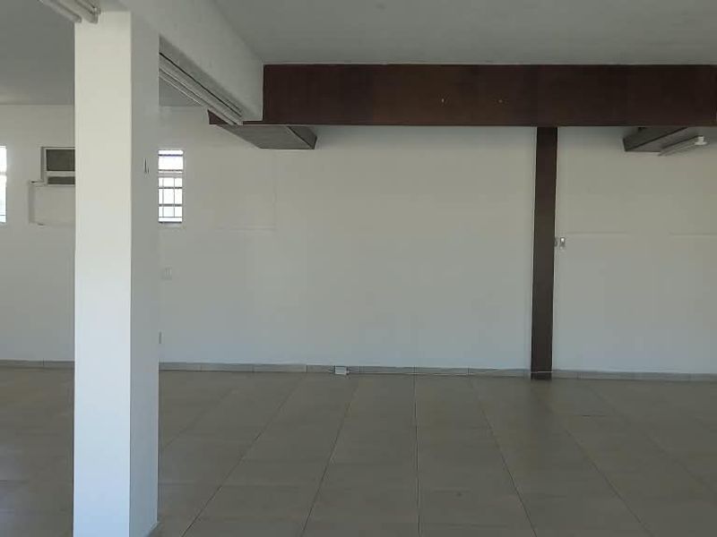 Spacious open-plan retail area featuring tiled flooring, structural support columns, and exposed beams, providing a versatile blank canvas for various business layouts.