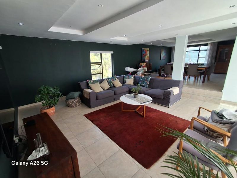 Spacious open-plan living and dining area featuring tiled flooring, recessed downlighting, and a modern bulkhead ceiling design.
