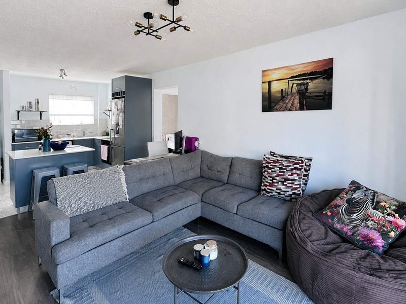 Open-plan living area featuring a modern kitchen with island, integrated cabinetry, and a seamless transition between the kitchen and lounge space.