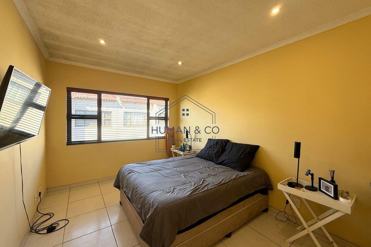 A bedroom featuring tiled flooring, recessed ceiling lighting, and large windows providing natural light.