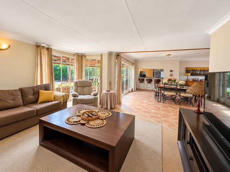 Spacious open-plan living and dining area featuring tiled and carpeted flooring, with seamless access to the outdoor patio through large sliding glass doors.