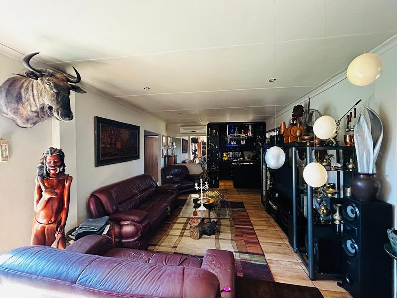 Spacious living room featuring tiled flooring, recessed lighting, an integrated air conditioning unit, and a built-in bar area at the rear.