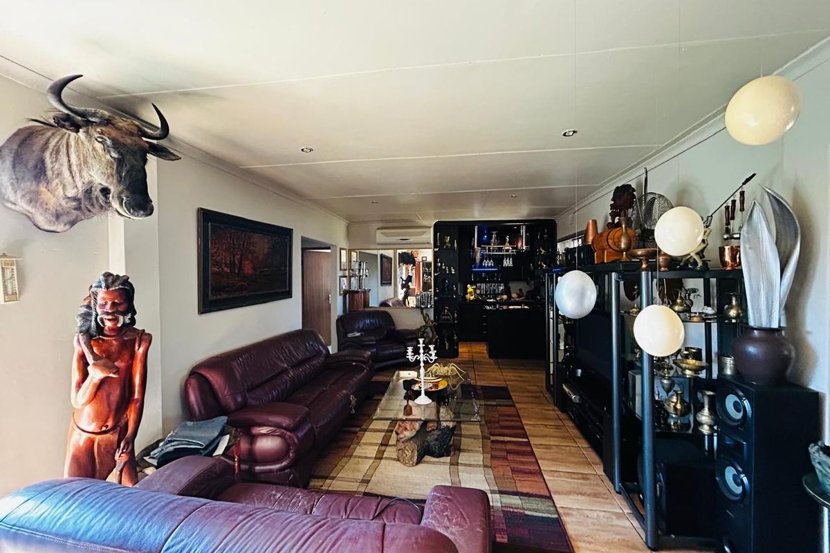 Spacious living room featuring tiled flooring, recessed lighting, an integrated air conditioning unit, and a built-in bar area at the rear.