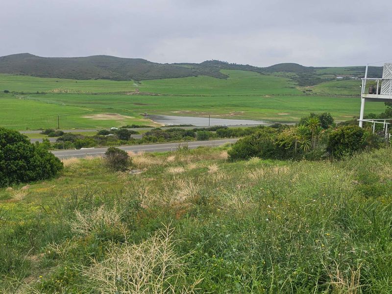 A view of the vacant residential land featuring natural vegetation with a scenic landscape and distant hills in the background.