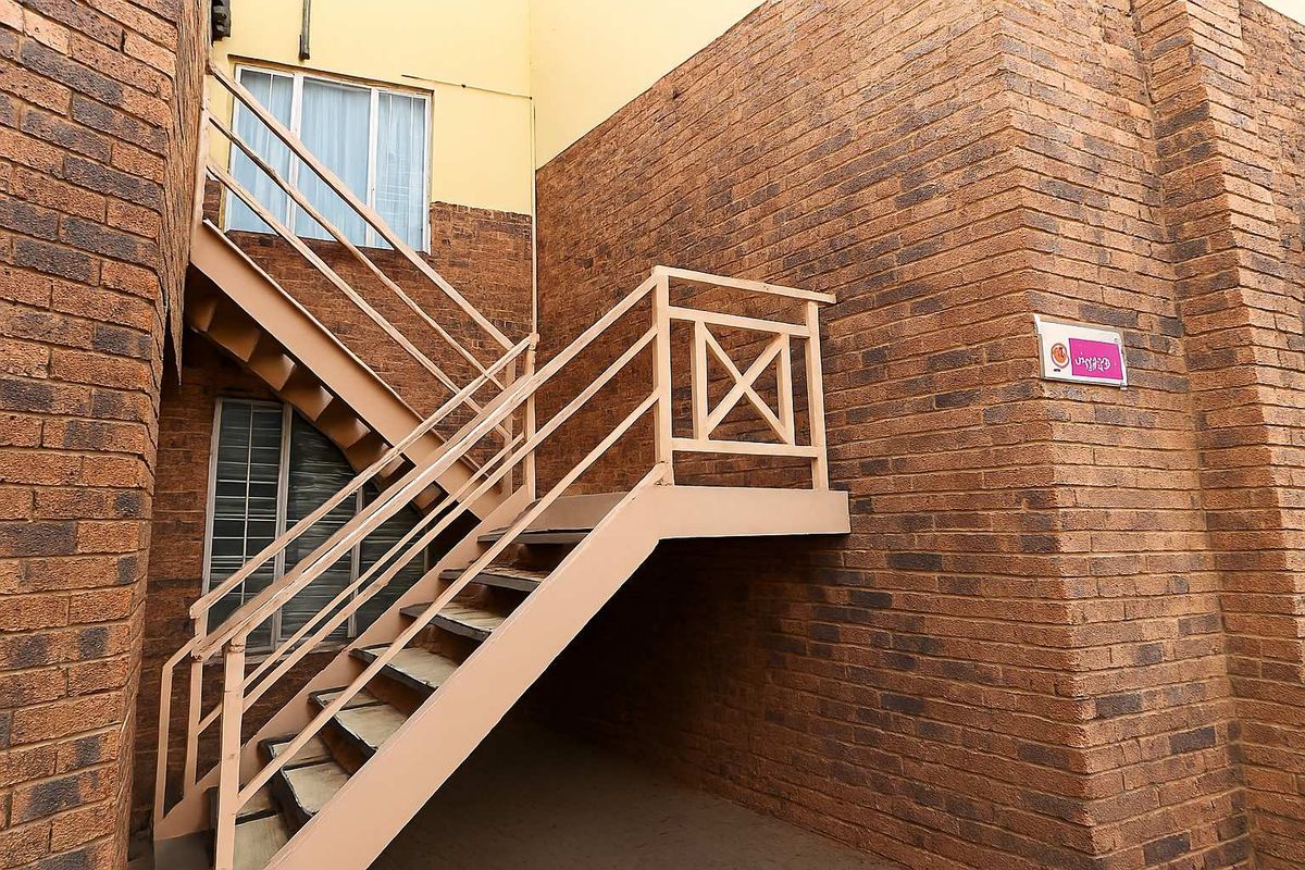 Exterior view of a commercial office building featuring a face-brick facade and an external metal staircase providing access to upper levels.