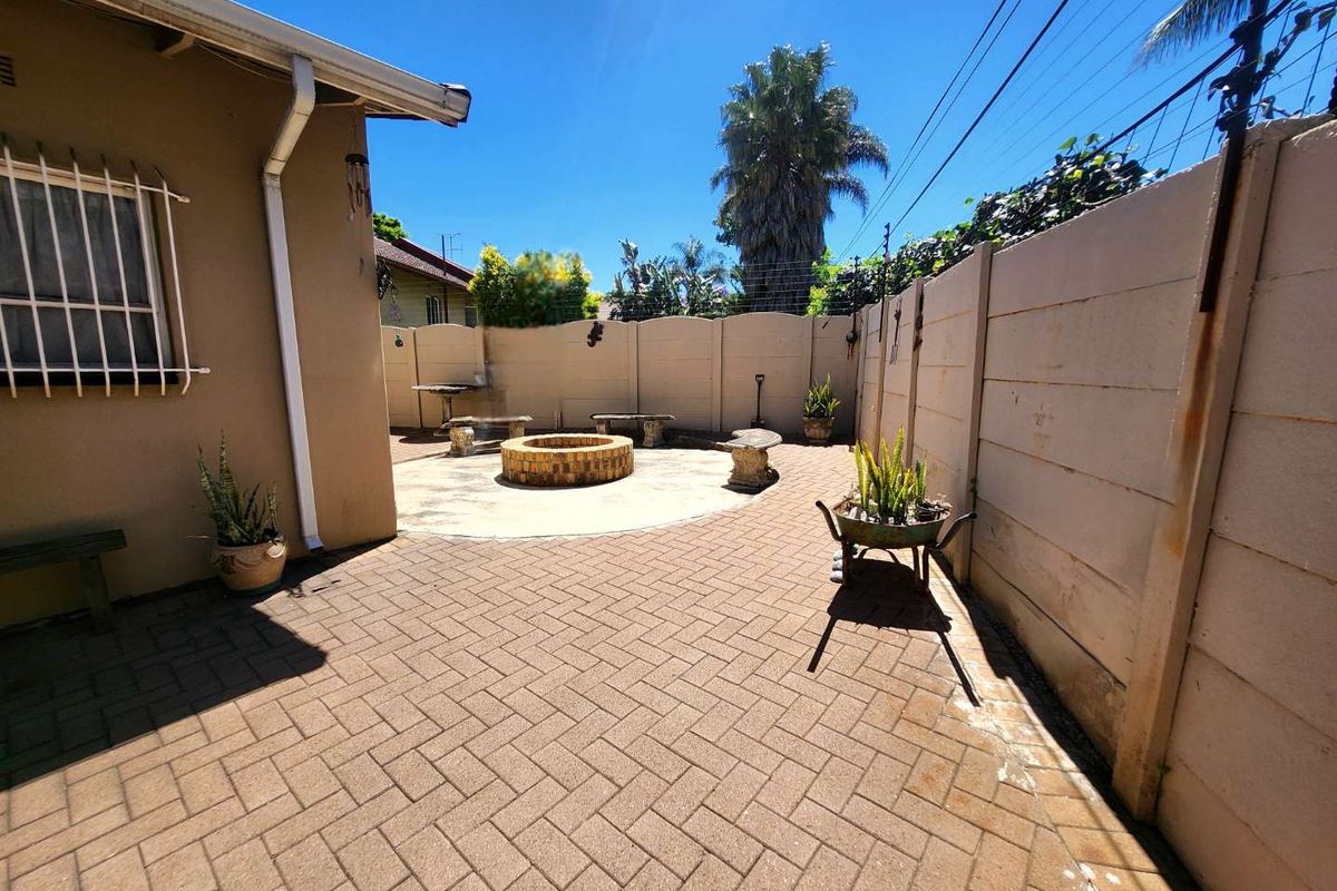A private rear courtyard featuring paved flooring, a built-in fire pit, and secure boundary walling, ideal for outdoor entertaining.