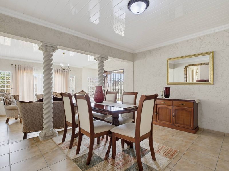 Open plan dining and living area featuring decorative columns, tiled flooring, and a tongue and groove ceiling.