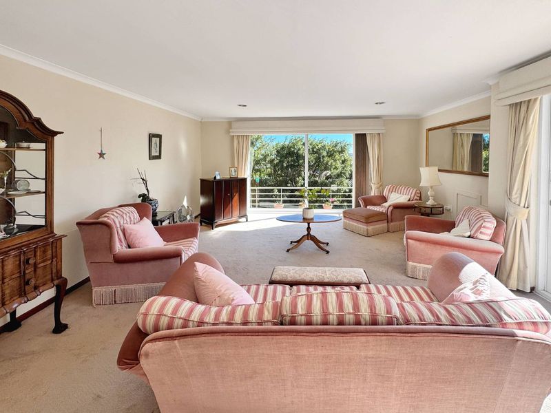 Spacious living room featuring neutral carpeting, recessed lighting, and large sliding glass doors that provide access to an outdoor balcony area.
