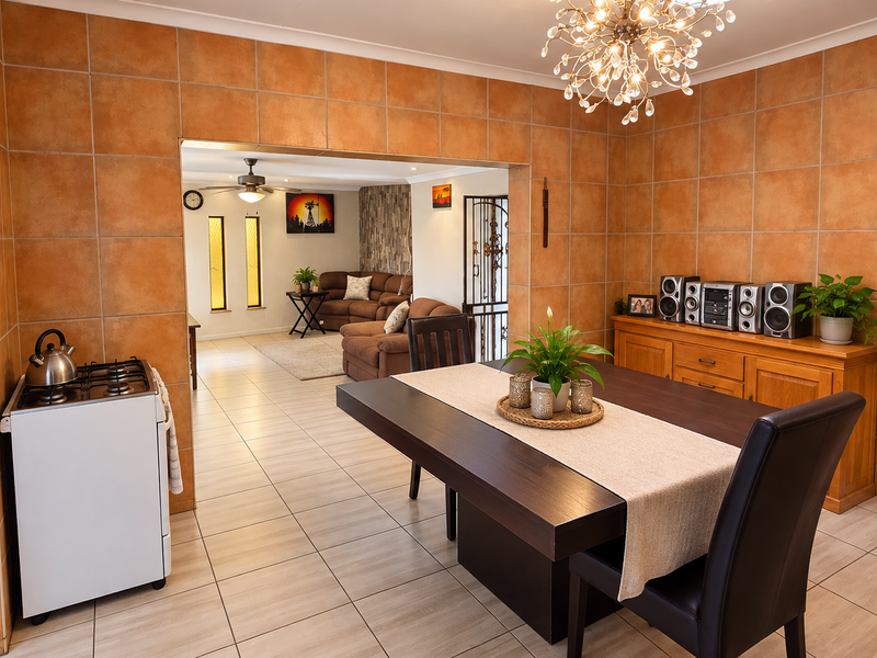 Open plan dining area featuring large format ceramic wall tiles, tiled flooring, and an archway leading into the adjacent living room space.