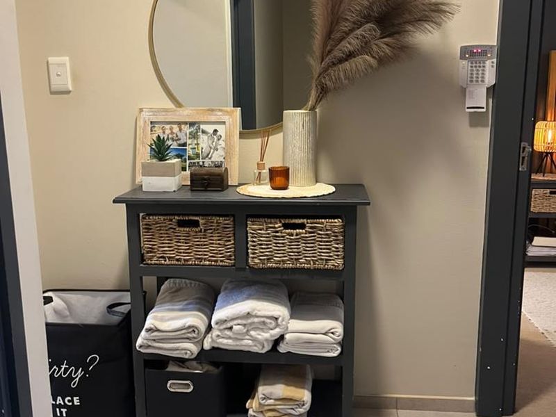 A functional entryway featuring tiled flooring and a wall-mounted security alarm keypad, providing a clean and welcoming transition into the home.