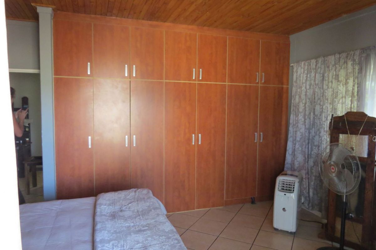 Bedroom featuring extensive floor-to-ceiling built-in wooden cabinetry, tiled flooring, and a timber-clad ceiling.
