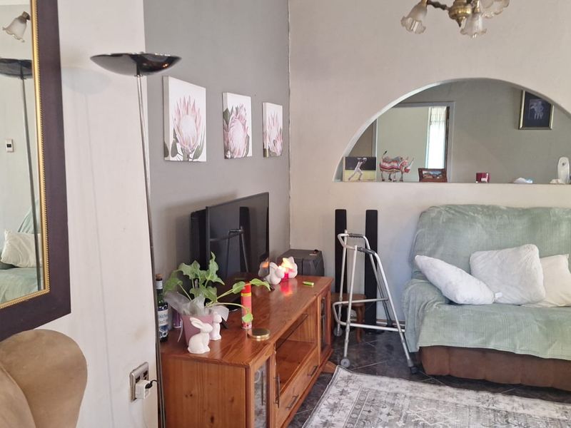 A living room featuring tiled flooring and a distinctive arched wall niche, providing a cozy and functional space for relaxation.