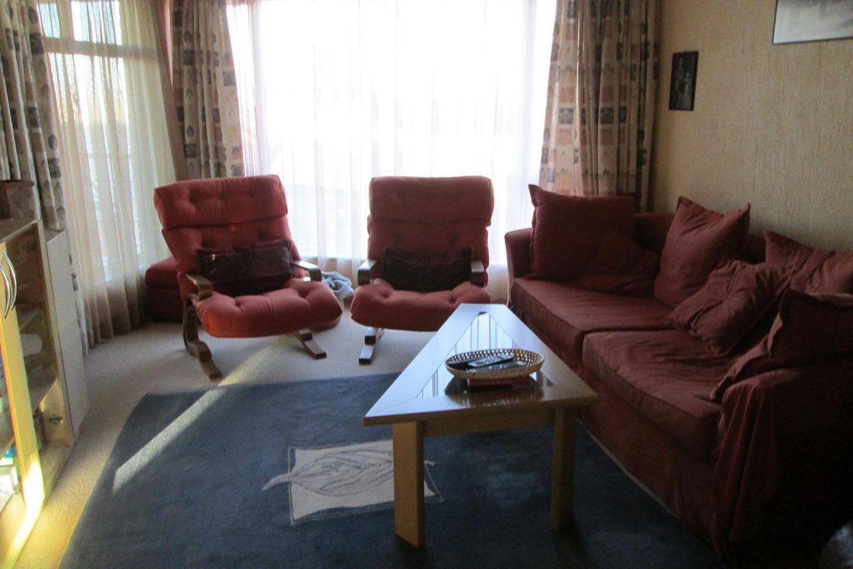 A comfortable living room featuring large windows that allow for ample natural light, creating a bright and inviting atmosphere.