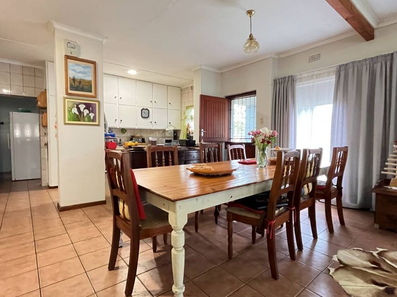 Open plan dining and kitchen area featuring tiled flooring, built-in cabinetry, and direct access to the outdoor space via a sliding glass door.