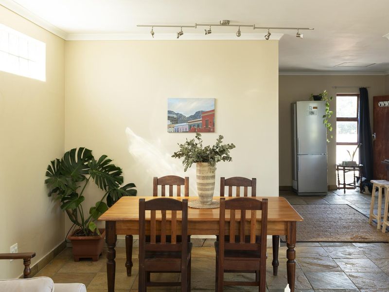 Dining area featuring stone tile flooring, track lighting, and a glass block window, providing a functional space for meals.