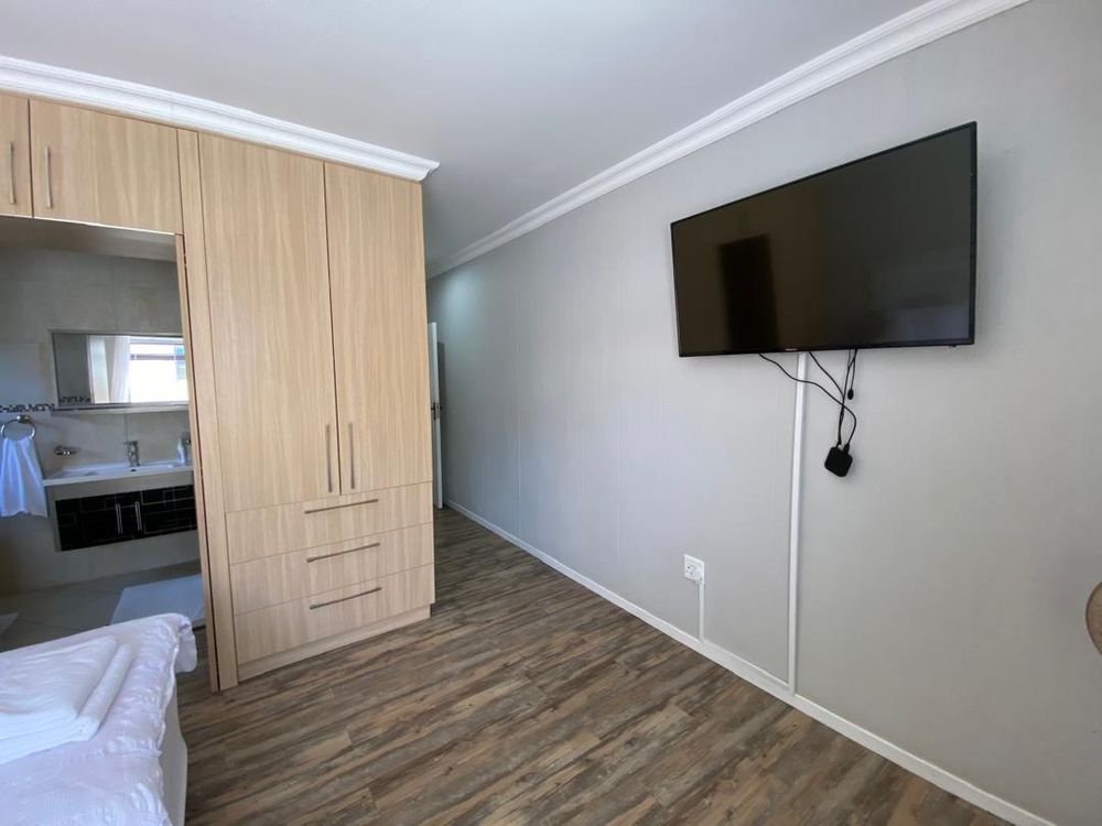 Ground floor, bedroom 3 with built-in cupboards, TV and en-suite bathroom. 