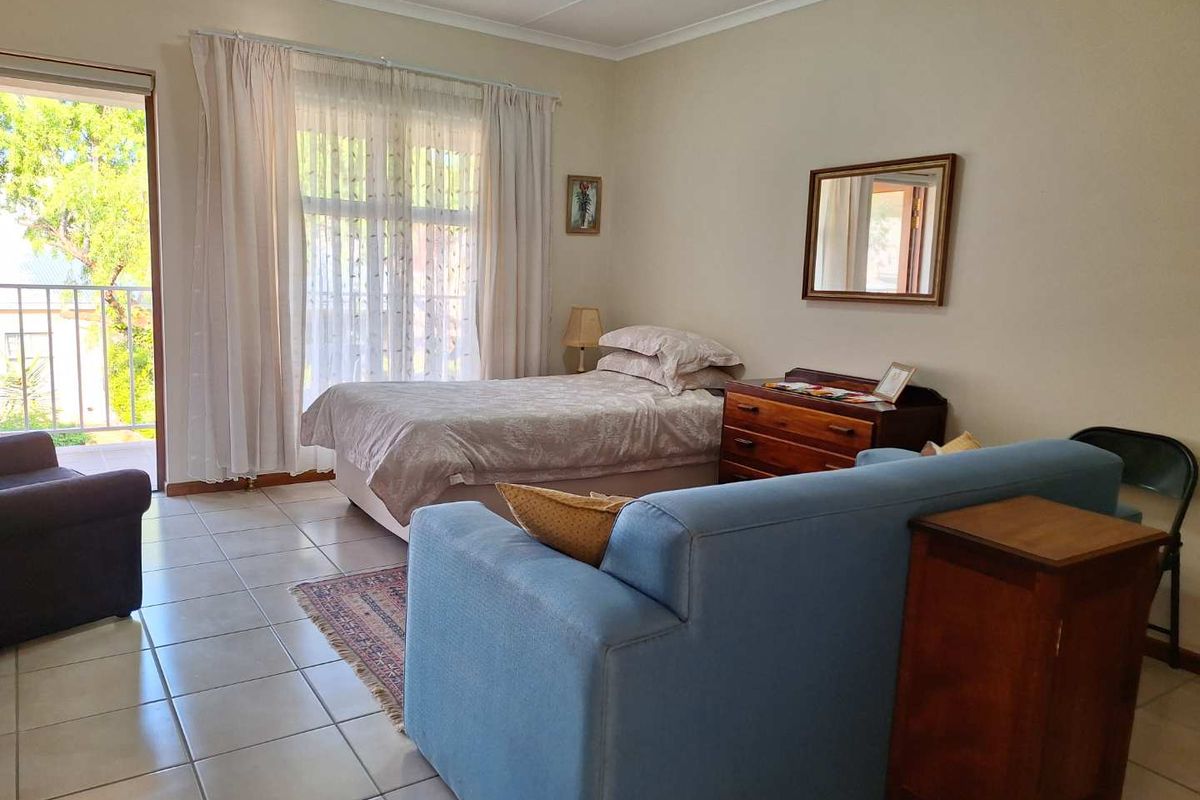 A bedroom featuring tiled flooring and a sliding glass door providing access to a private balcony.