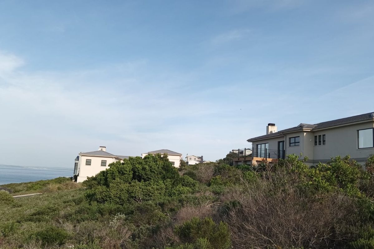 A scenic view of coastal residential properties situated on a hillside overlooking the ocean.