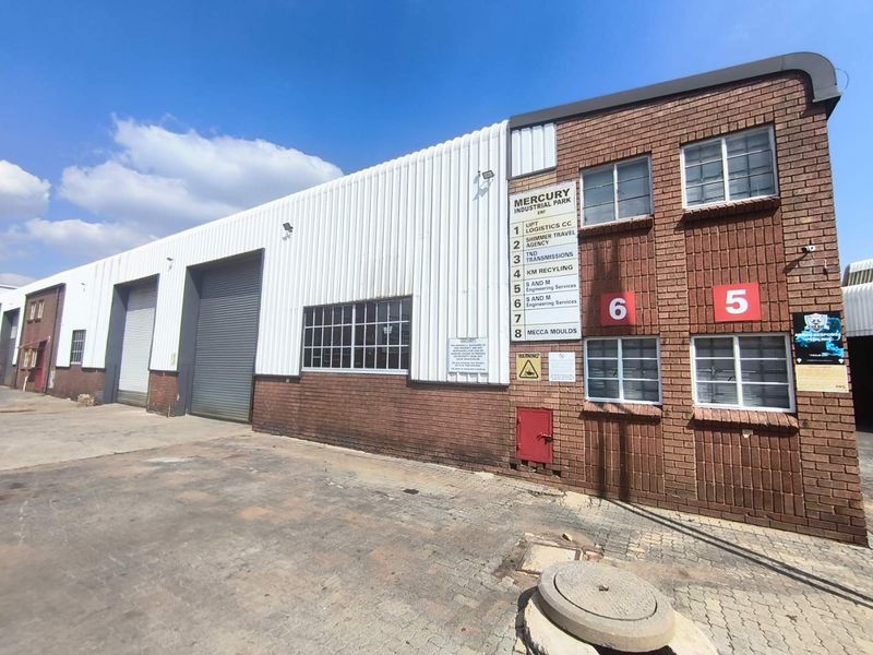 Exterior view of Mercury Industrial Park featuring multiple roller shutter doors, brick and metal facade, and clear unit signage for commercial logistics or manufacturing use.