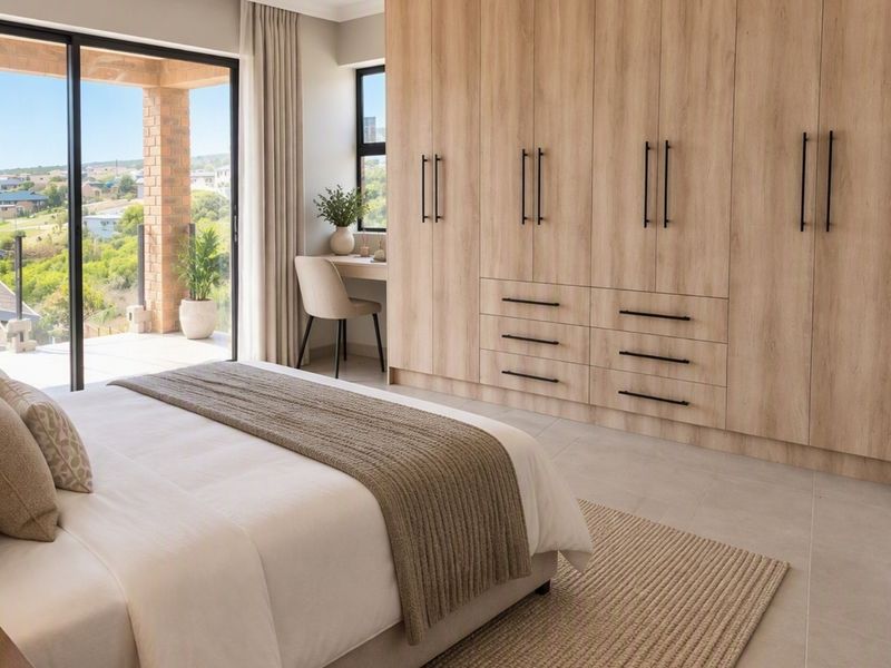 Modern bedroom featuring extensive built-in cabinetry, neutral tiled flooring, and large sliding doors opening to a private balcony with scenic views.