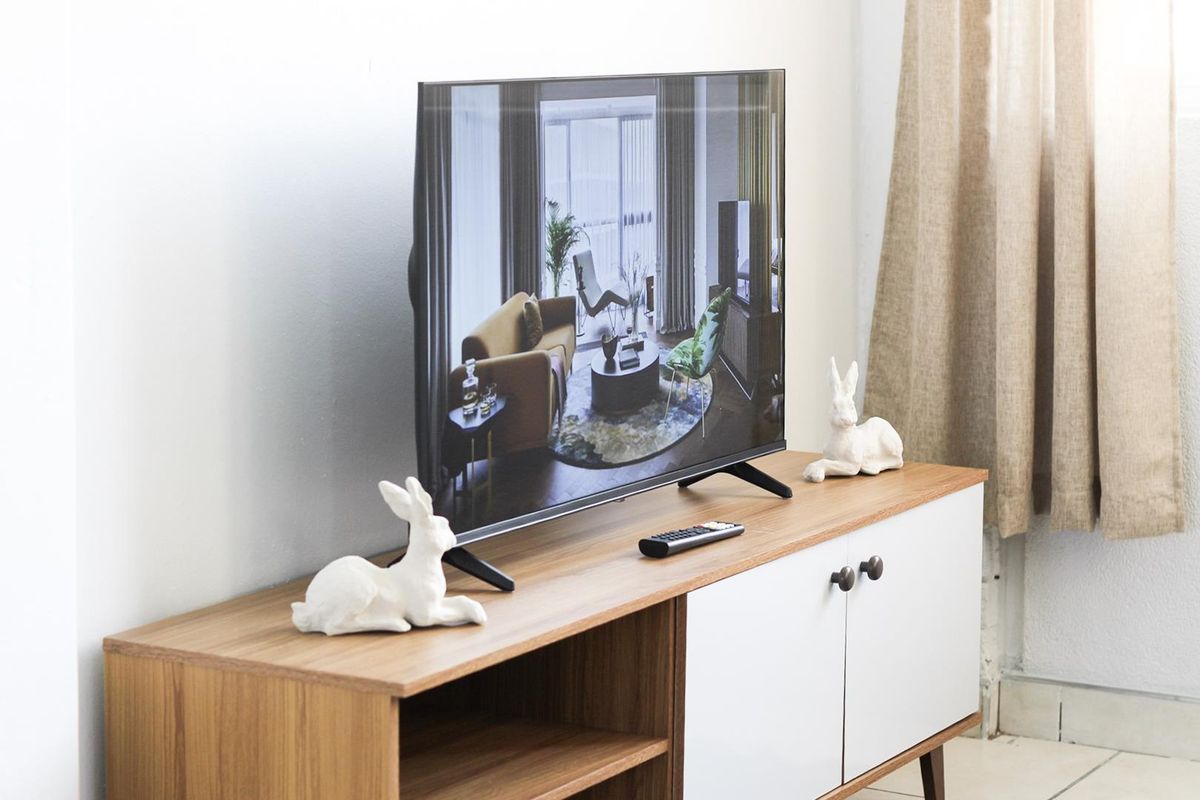 A close-up view of a television set placed on a modern wooden media console in a living area.