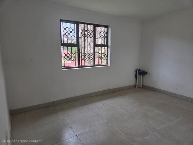 An empty bedroom featuring tiled flooring and a window fitted with a security gate, offering a blank canvas for potential interior design.