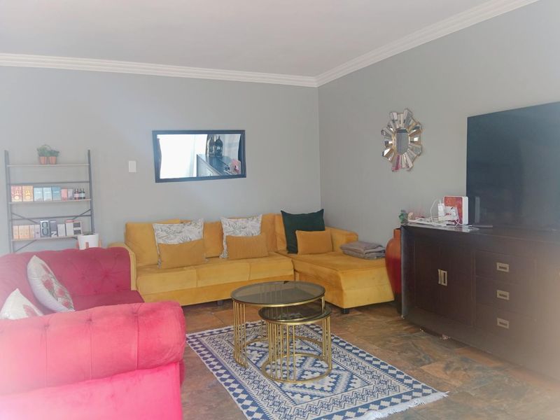 A living room featuring tiled flooring and crown molding, providing a neutral base for interior design updates.