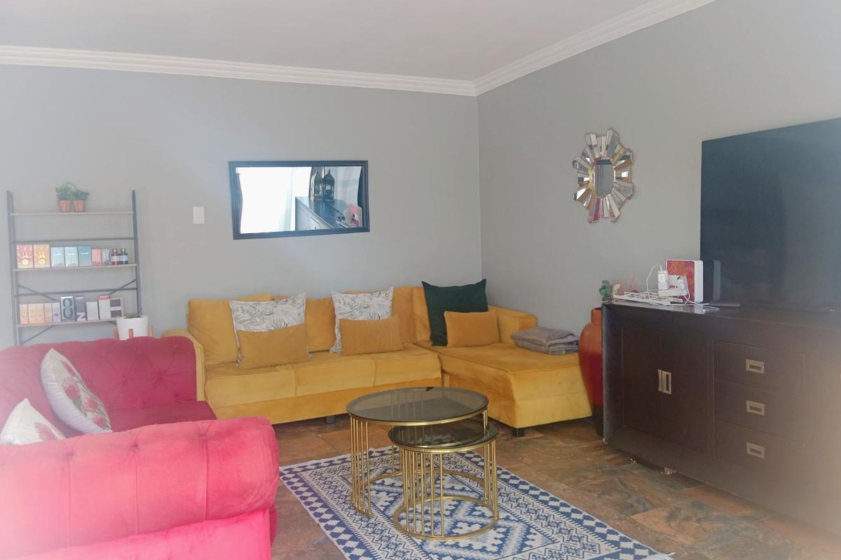 A living room featuring tiled flooring and crown molding, providing a neutral base for interior design updates.