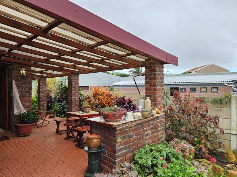 Covered outdoor patio featuring brick paving, a built-in brick bar counter, and a timber pergola structure, ideal for outdoor entertaining.