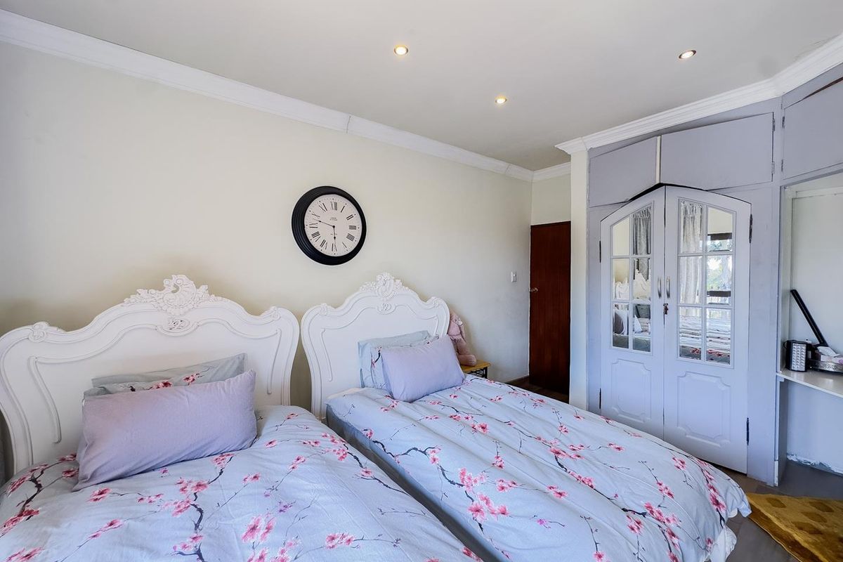 A bedroom featuring built-in cupboards with mirrored doors, recessed downlighting, and crown molding.