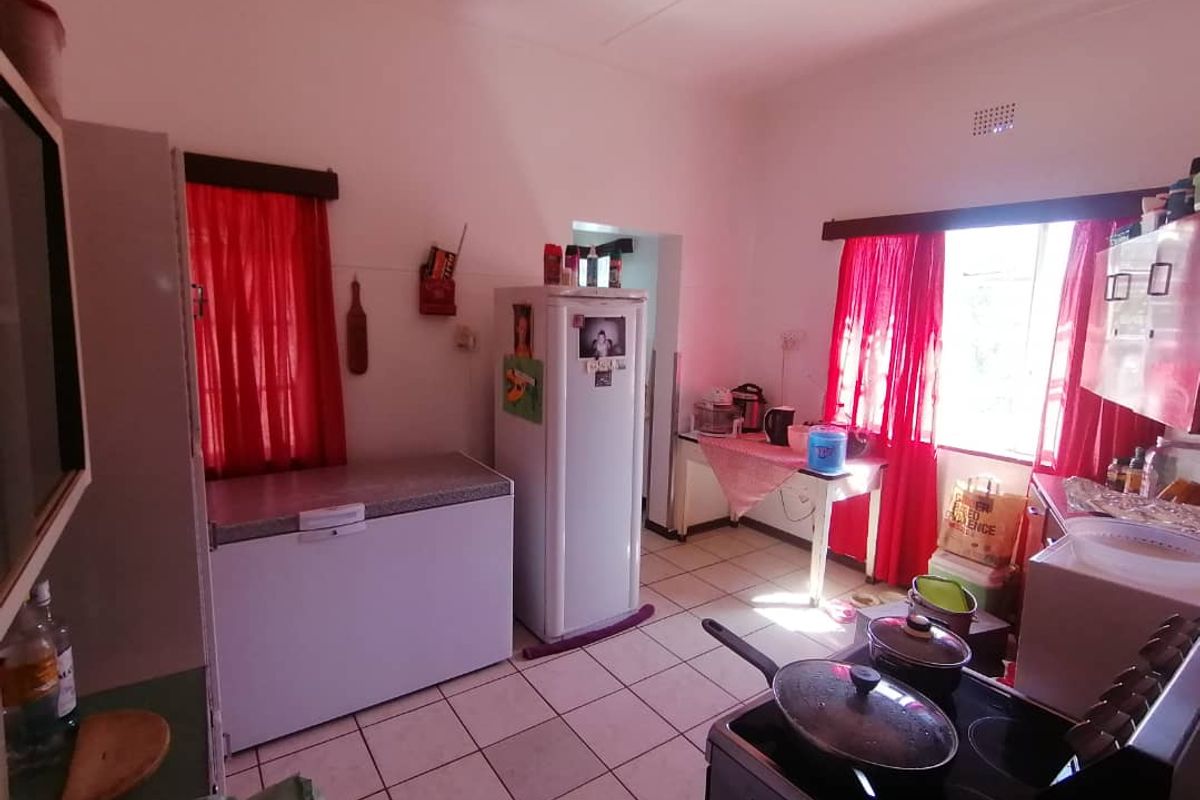 A functional kitchen space featuring tiled flooring and basic cabinetry, offering a practical layout for daily meal preparation.