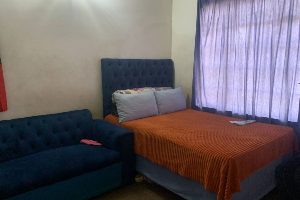 A bedroom featuring a window with curtains and standard wall finishes.