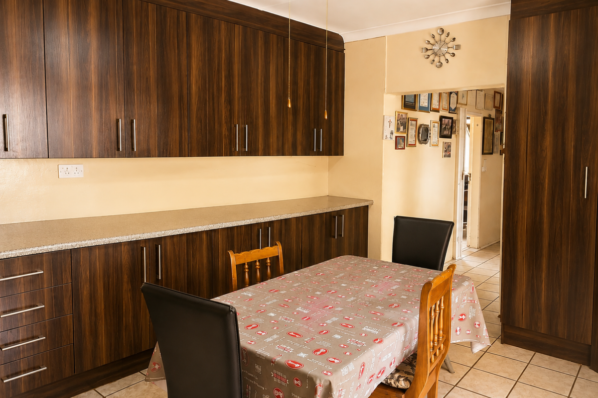 A functional kitchen featuring dark wood-grain cabinetry, ample counter space, and tiled flooring, providing a practical layout for daily meal preparation.