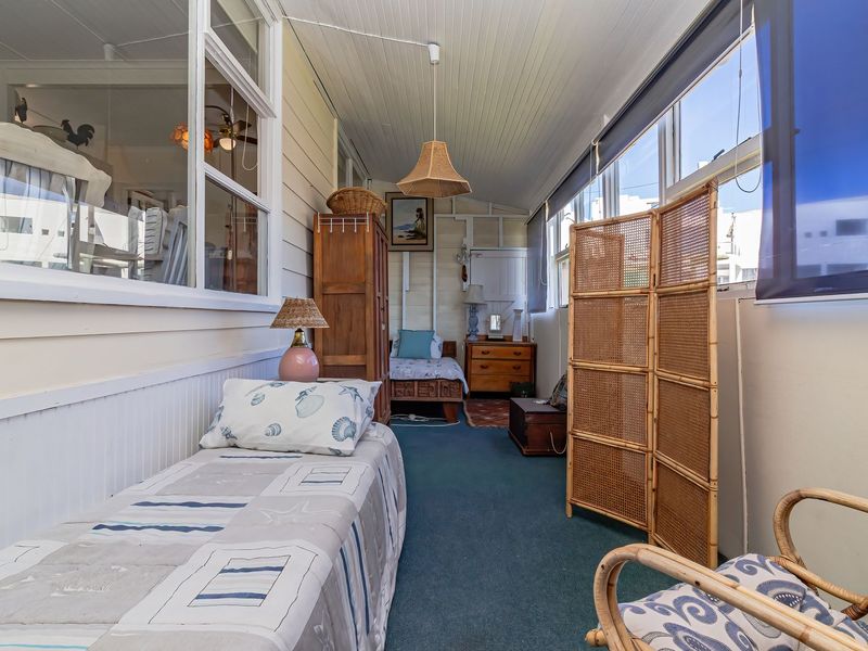 Enclosed sunroom or patio area featuring timber wall cladding, timber ceiling, and large windows providing ample natural light.