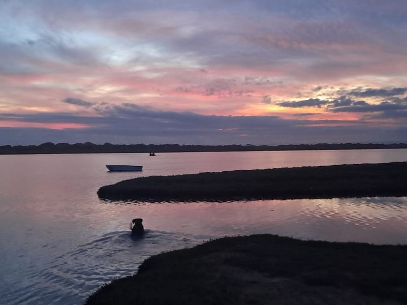 A scenic sunset view over the lagoon, showcasing the natural landscape and tranquil water setting of the property.