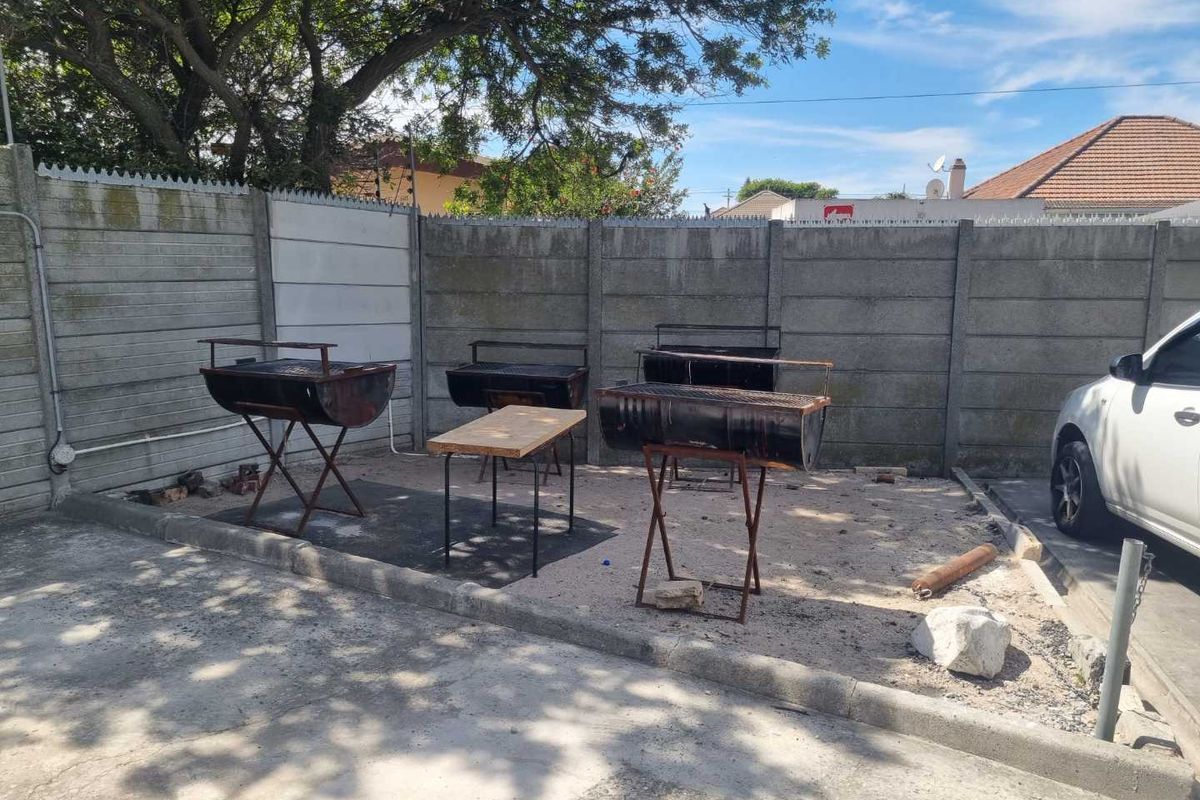 Outdoor paved area featuring a precast concrete boundary wall, suitable for a communal braai or utility space.