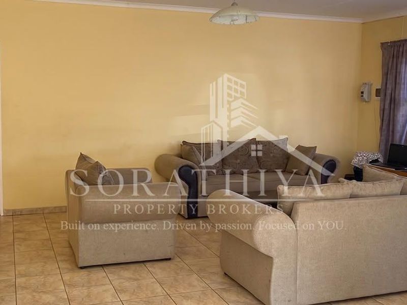 A spacious living room featuring tiled flooring and neutral wall finishes, providing a functional and comfortable area for relaxation.