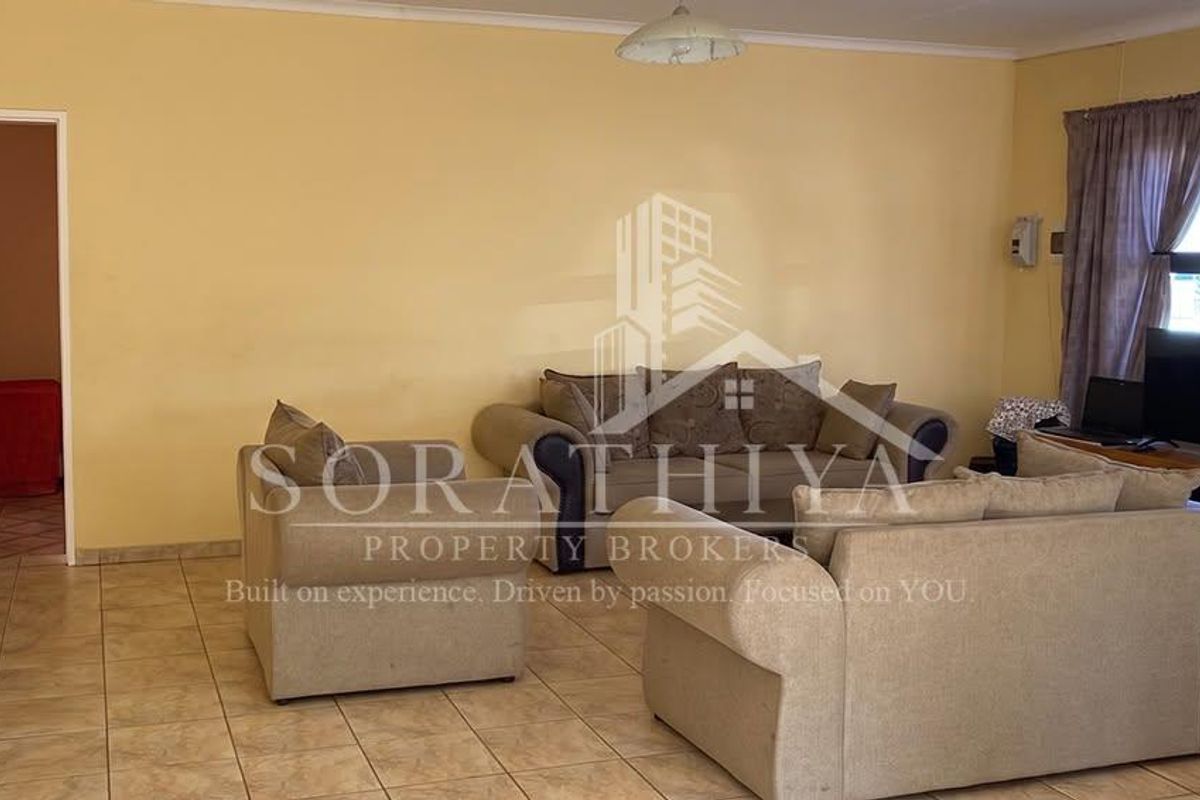 A spacious living room featuring tiled flooring and neutral wall finishes, providing a functional and comfortable area for relaxation.